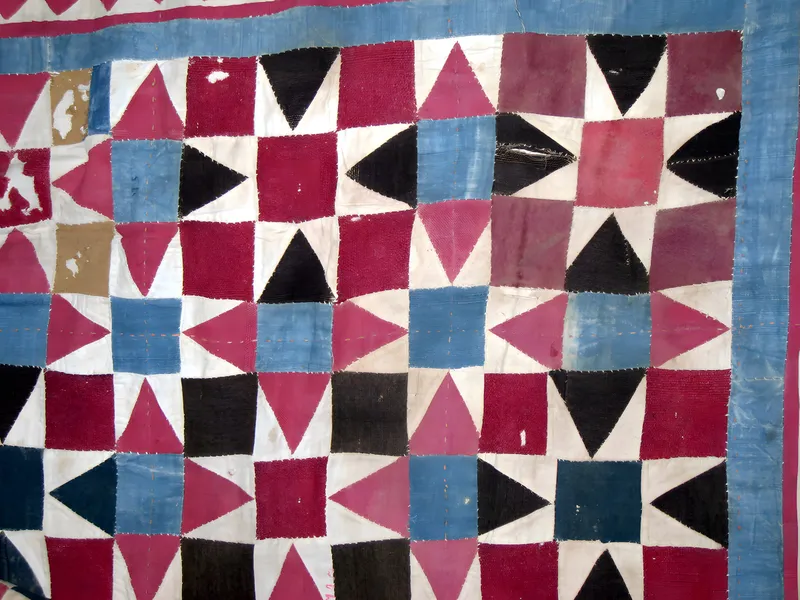 Pieced quilt of triangles and squares