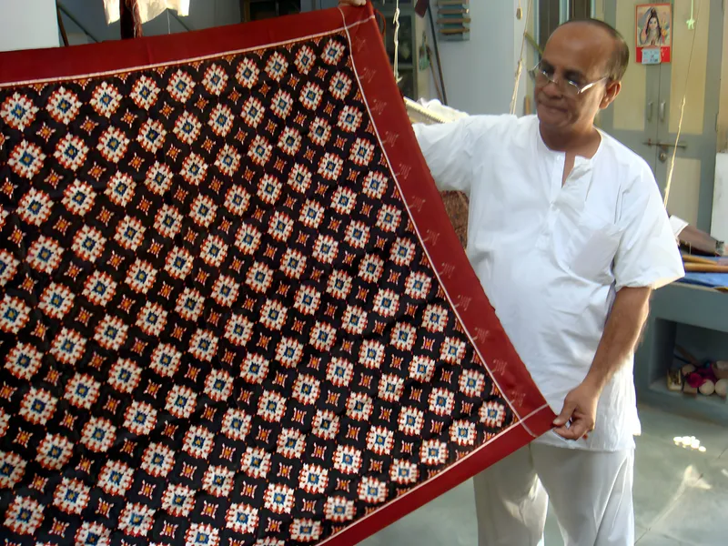 A patola weaver presents a sari