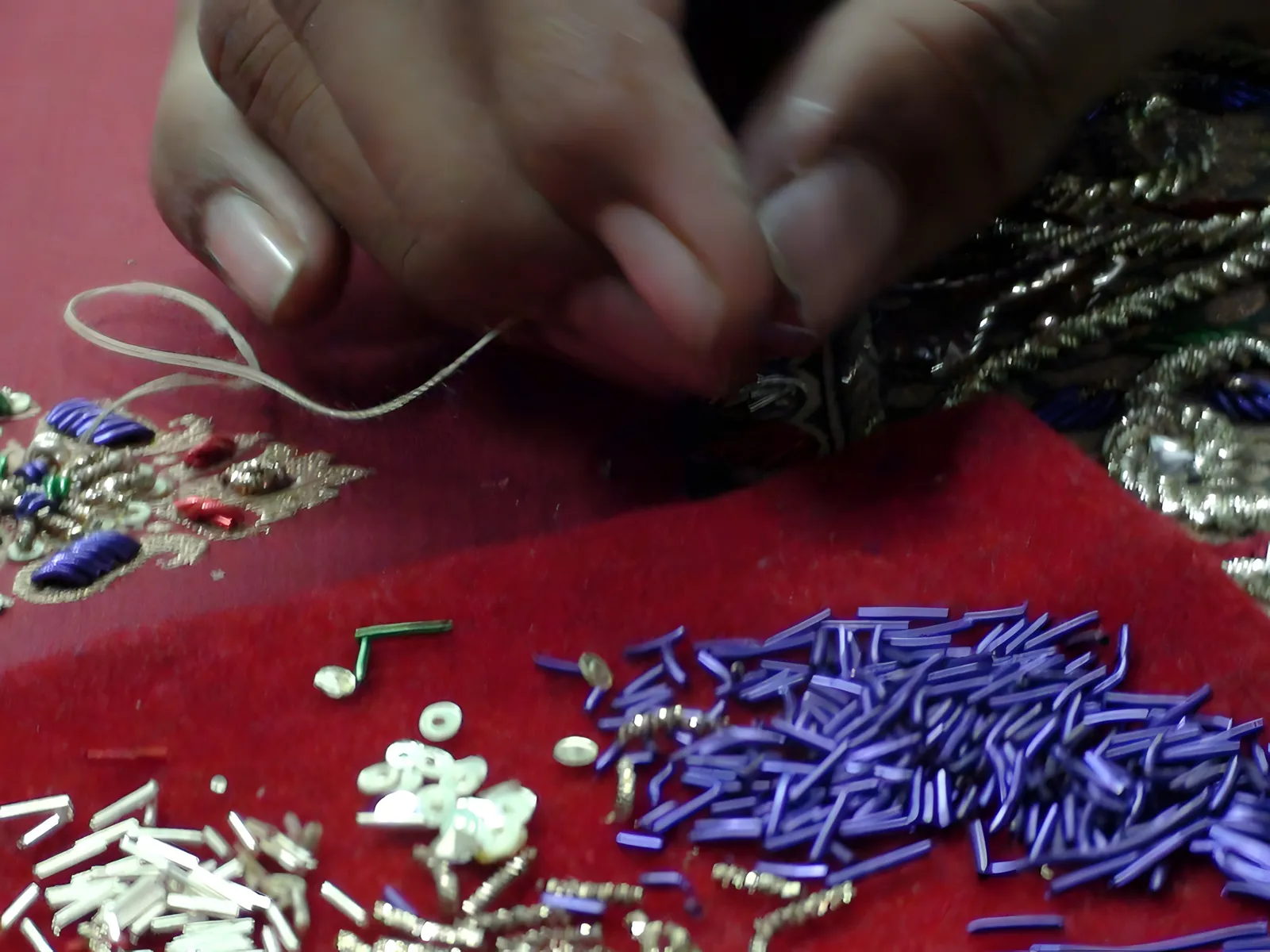 Sequins, beads and bullion on red cotton